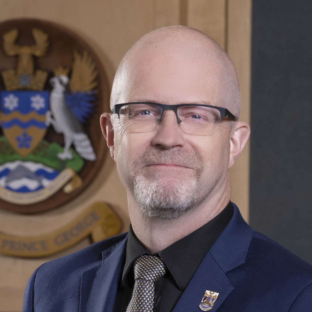 Headshot of Councillor Garth Frizzell in council chambers, with City of Prince George crest partially visible in background.